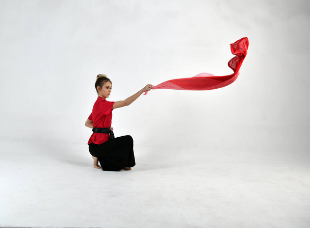 menina bonita em preto e vermelho dançando com um lenço de combate
 - Foto, Imagem