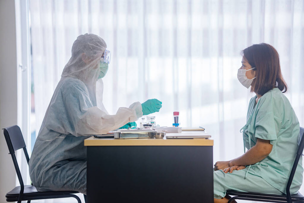 aziatische vrouwelijke patiënt wordt gerustgesteld door vrouw arts in ziekenhuis kamer - Foto, afbeelding