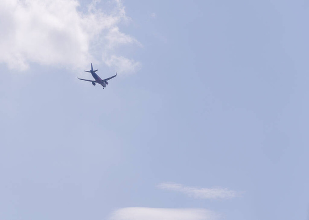 repülő elrepül a távolba ellen kék ég - Fotó, kép