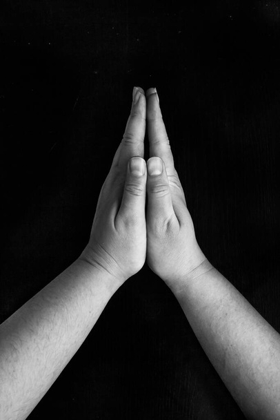 Black Lives Matter.Hände zu einer Geste des Gebetes gefaltet, auf schwarzem Hintergrund - Foto, Bild