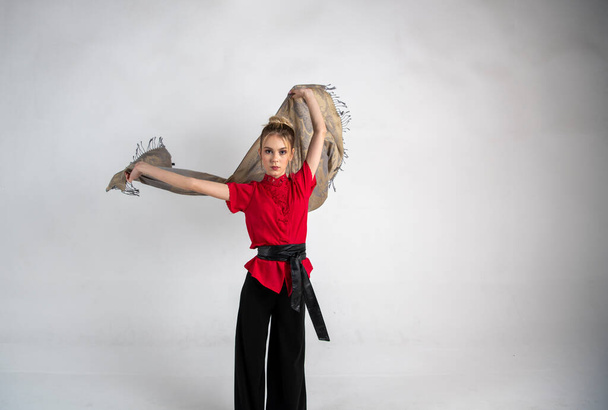 schönes Mädchen in schwarz und rot tanzt mit einem Kampfschal - Foto, Bild