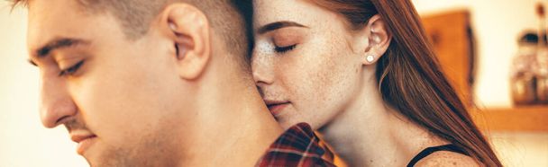 Lovely caucasian woman with red hair and freckles embracing her lover with closed eyes - Photo, Image