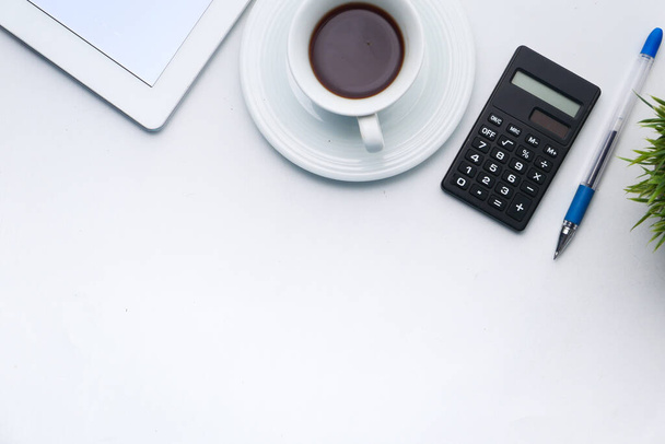Schreibtisch mit digitalem Tablet, Tee und Taschenrechner auf weißem Hintergrund  - Foto, Bild