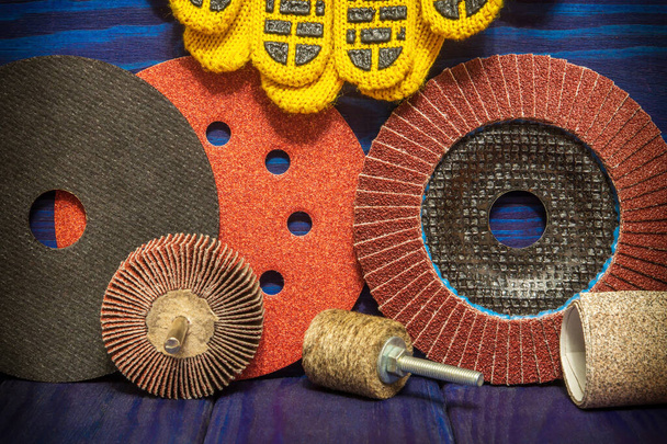 Набір абразивних інструментів і робочих рукавичок на синіх старовинних дерев'яних дошках майстер використовується для шліфування предметів
 - Фото, зображення