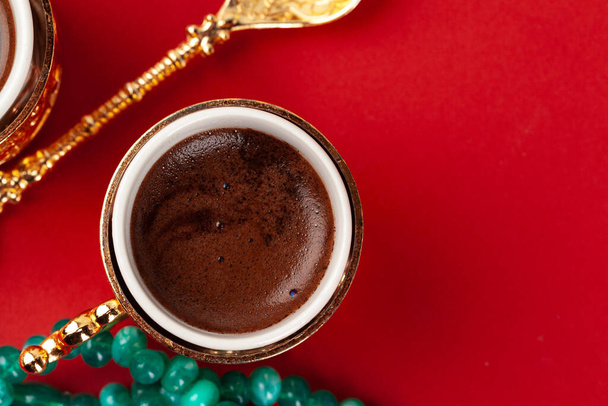Turkish coffee in a golden oriental cup on red background - Photo, Image