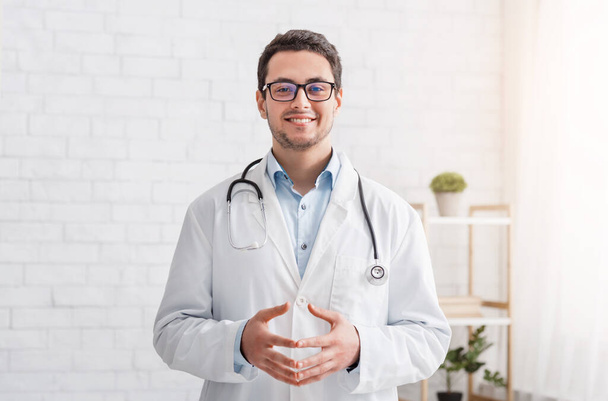 Здоров'я та медичний блог. Усміхнений лікар чоловічої статі в білому пальто і окулярах
 - Фото, зображення