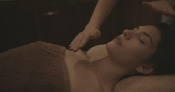 Woman doing reiki alternative medicine treatment at holistic therapy spa - Кадры, видео