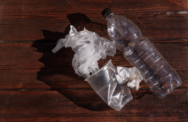 Plastic glass and bottle. A celenfa pack on a dark wooden background. - Photo, Image