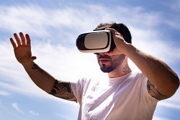 hombre usando gafas de realidad virtual cielo fondo
 - Foto, Imagen