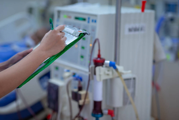 L'infermiere in dialisi sta controllando la macchina di dialisi prima della disfunzione renale sostitutiva dell'emodialisi o dell'insufficienza renale nell'unità di terapia intensiva
. - Foto, immagini