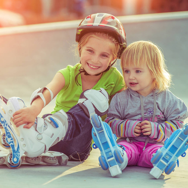 two little sisters in a roller skates - Фото, изображение