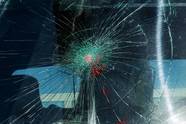 Broken car windshield. Web of radial cracks, crack on triple windshield. Broken windshield car, damaged glass with traces of an oncoming stone on road or trace of downed pedestrian or animal on road - Photo, Image