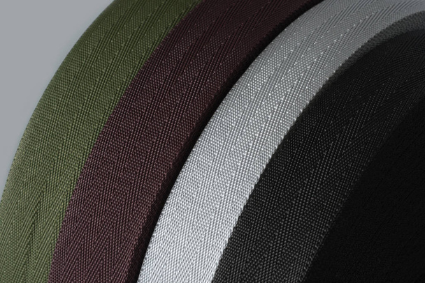 rollos de cinta textil sobre fondo gris. producción de cinta de color
. - Foto, Imagen
