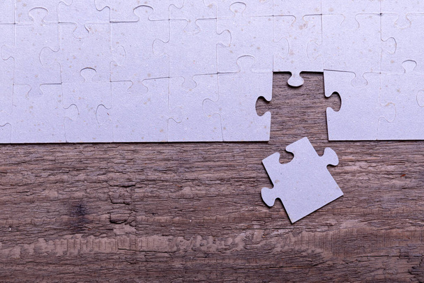 Jigsaw puzzle pieces lying on old wooden rustic boards. Conceptual of innovation, solution finding and integration. - Photo, Image