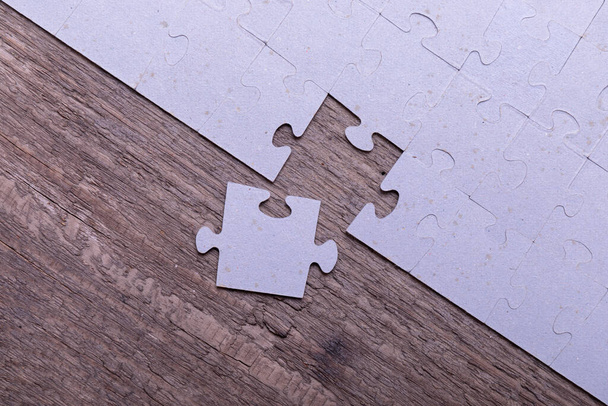 Puzzleteile liegen auf alten rustikalen Holzbrettern. Konzept für Innovation, Lösungsfindung und Integration. - Foto, Bild