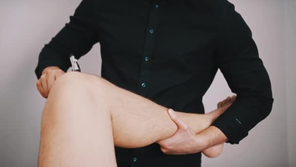 Chiropractische behandeling - Doctor specialist testen van de reactie op medische hamer op een knie. Reflexcontrole - Video