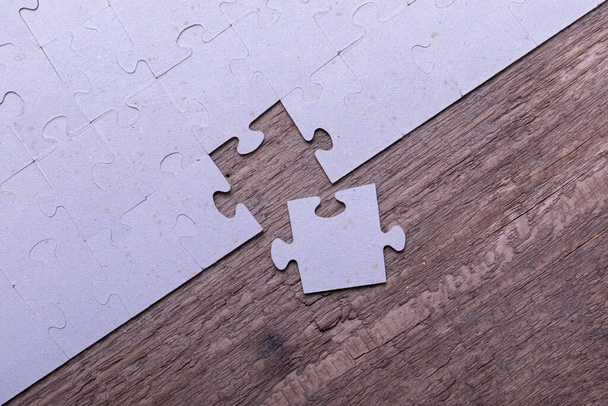 Pezzi di puzzle che giacciono su vecchie tavole di legno rustico. Concetto di innovazione, ricerca di soluzioni e integrazione
. - Foto, immagini