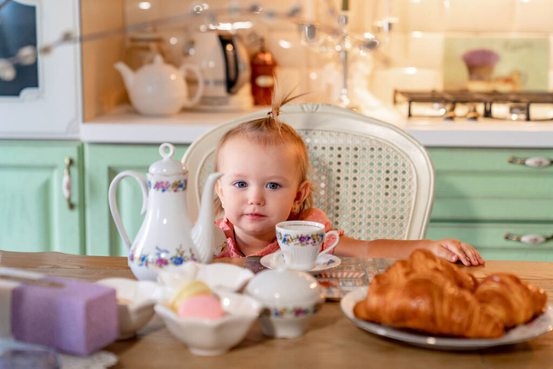 little girl made Cup of tea with cake in kitchen.festive lunch.playing with kids - Fotografie, Obrázek
