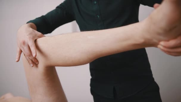 Jeune homme se faisant examiner le genou par un spécialiste. Physiothérapie flexibilité du genou - Séquence, vidéo