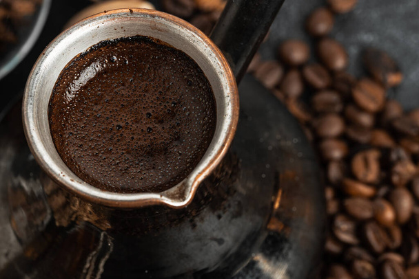 Coffee beans and turk on dark surface - Zdjęcie, obraz