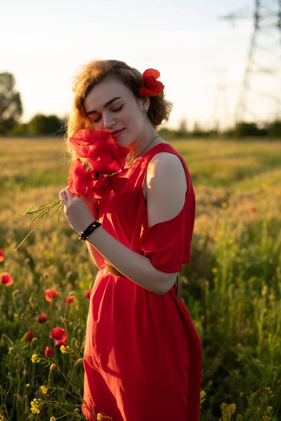 Woman sniff flowers in a poppy field - Zdjęcie, obraz