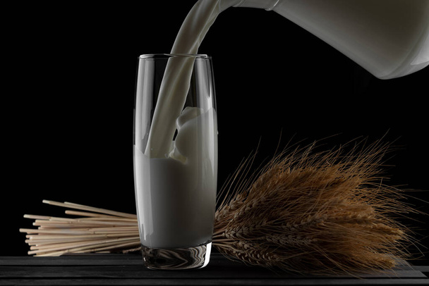 jug of milk and a glass on a black background - Zdjęcie, obraz