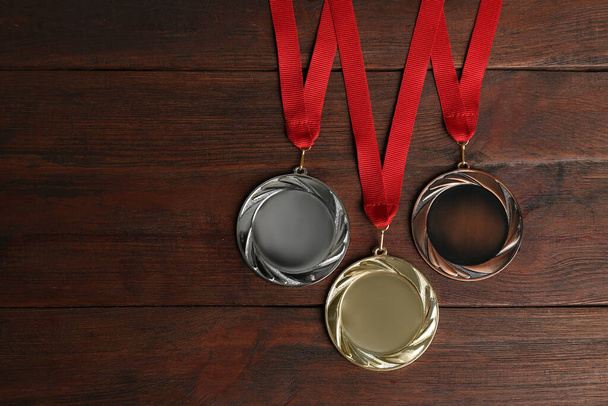 Gold, silver and bronze medals on wooden background, flat lay. Space for design - Photo, Image