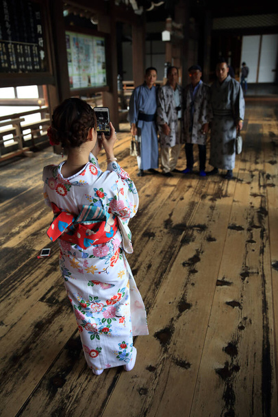 Kyoto, Giappone, 12 aprile 2018 - I turisti nei kimono tradizionali scattano foto nel Tempio di Higashi Honganji. Higashi Honganji è stata fondata nel 1602 dal fucile Tokugawa Ieyasu - Foto, immagini