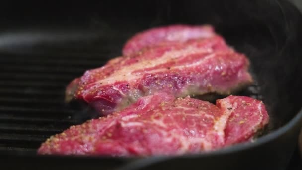 Cooking steaks in grill pan - Materiał filmowy, wideo