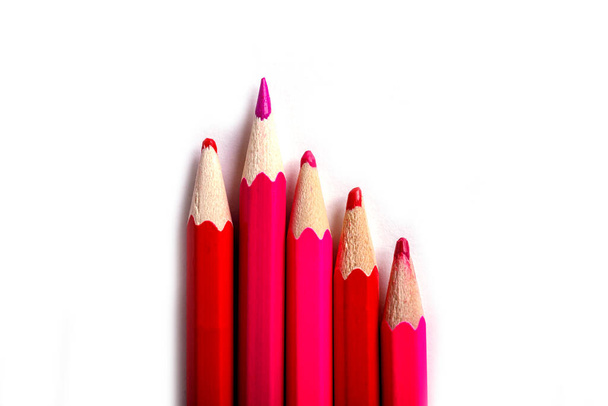 Un crayon aiguisé se détachant des contondants. C'est facile d'être belle si on ne fait rien de concept. Crayons rouges sur blanc. - Photo, image