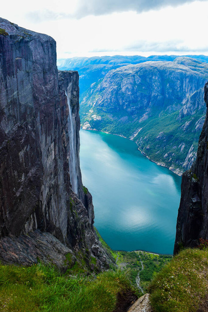 Kilátás Lysefjorden egy hasadékon keresztül két szikla között 984 méter magas, ahol a híres Kjeragbolten ragadt a közelben - a legveszélyesebb kő a világon. Mountain Kjerag, Rogaland megye, Norvégia. - Fotó, kép