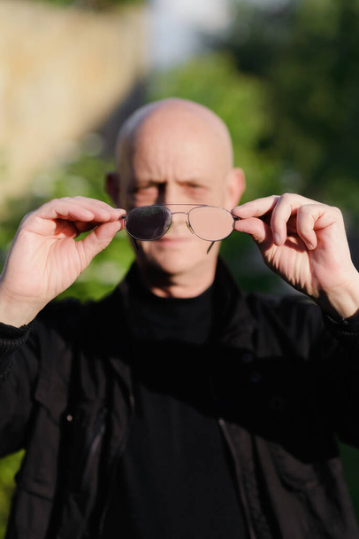 Viejo sostiene gafas de visión en su mano
 - Foto, Imagen