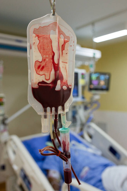 Кров'яний мішок з кров'ю майже вибігає до пацієнта
. - Фото, зображення