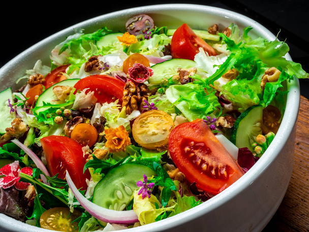 Salaatti erilaisia salaattia, tomaattia, sipulia, kurkkua ja pähkinöitä. - Valokuva, kuva