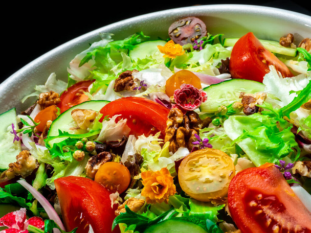 Salad of different types of lettuce, tomato, onion, cucumber and nuts. - Photo, Image