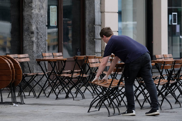 An employee prepares the terraces of a restaurant in central Brussels, as the country began easing lockdown restrictions following the coronavirus disease (COVID-19) outbreak in Belgium, June 8, 2020 - Фото, изображение