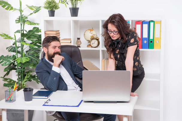 New ways to automate business processes. Managers work in modern office. Bearded man and sexy woman use laptop. Using modern computer technologies. Running modern business. Modern life - Photo, image