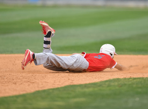 Honkbalspeler in actie tijdens een honkbalwedstrijd - Foto, afbeelding