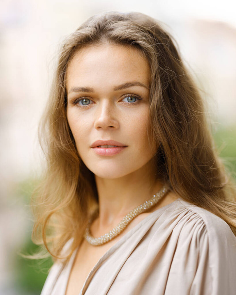 Closeup outdoors portrait of pretty caucasian lady with neutral makeup and healthy skin and wrinkles - Photo, Image