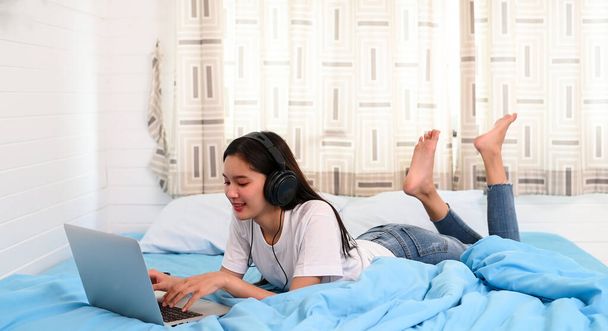 Azji nastolatek dziewczyna umieścić muzyka słuchawki w sypialni - Zdjęcie, obraz