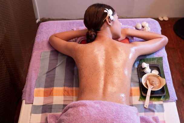 Mujer joven teniendo masaje con bolsas de hierbas en el salón de spa
 - Foto, Imagen