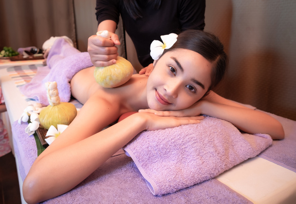 Young woman having massage with herbal bags in spa salon - Foto, Bild