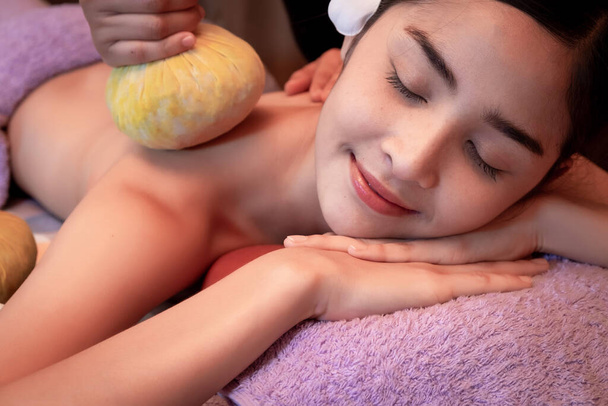 Jeune femme ayant massage avec des sacs à base de plantes dans le salon de spa
 - Photo, image