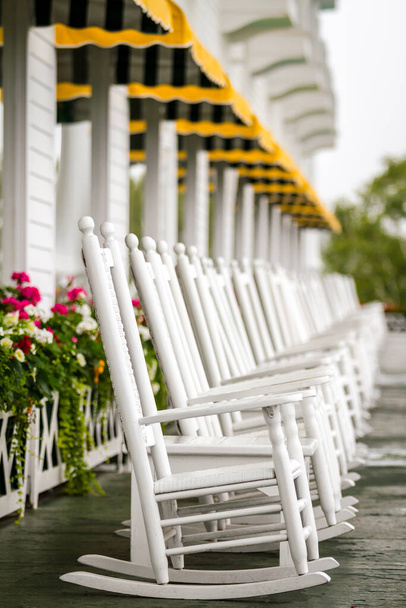 Αρκετές λευκές καρέκλες Rocking στο Long Porch απλά σας περιμένουν να έρθετε και να απολαύσετε σε ένα πολυτελές ταξίδι στο νησί Mackinac - Φωτογραφία, εικόνα