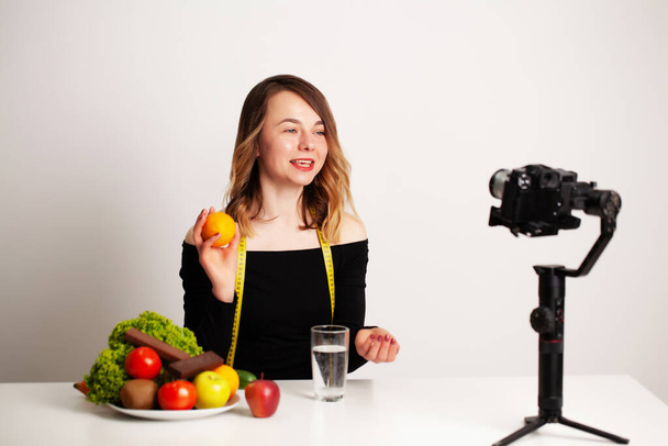Een jonge vrouw in lightroom schrijft een blog over gewichtsverlies en gezond eten - Foto, afbeelding