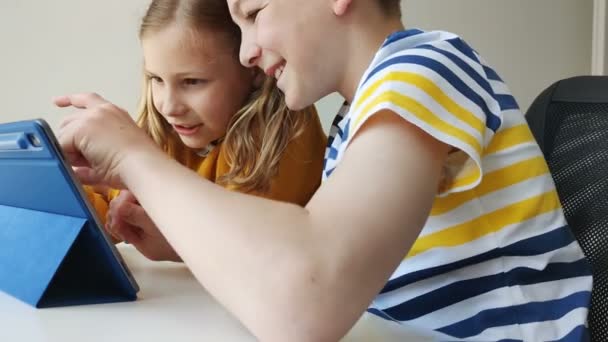 Two happy teenage siblings children surfing in internet and having fun together  - Felvétel, videó