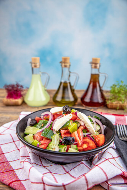 Mediterraner Salat (griechischer Salat) mit frischem Gemüse, Feta-Käse und schwarzen Oliven. Ansicht von oben. - Foto, Bild
