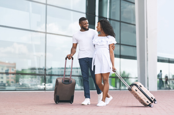Ready for travel. Black spouses walking with suitcases near airport building - Photo, Image
