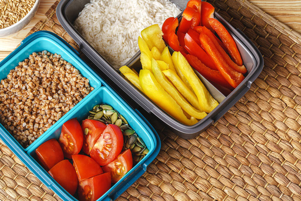 Two lunch boxes with cooked groats and cut vegetables - Photo, Image