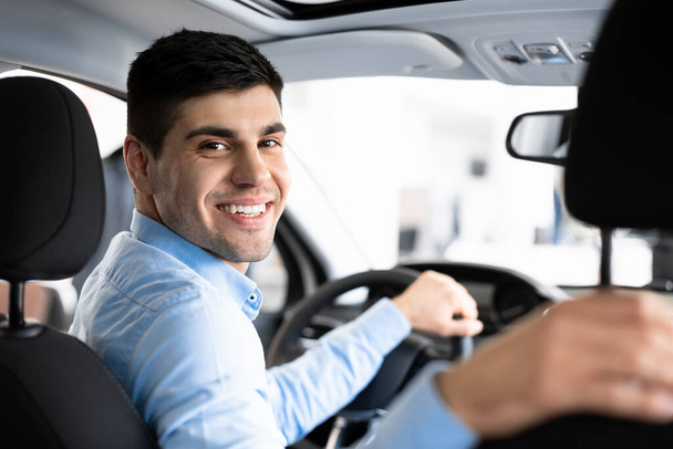 Szczęśliwy młody człowiek siedzi w swoim nowym samochodzie - Zdjęcie, obraz